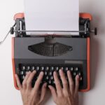 hand typing on typewriter